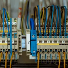 Zaciski elektryczne z kolorowymi przewodami, gotowe do podłączenia prądu budowlanego.