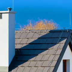 Na dachu domu widoczna jest instalacja odgromowa, chroniąca przed uderzeniami pioruna.