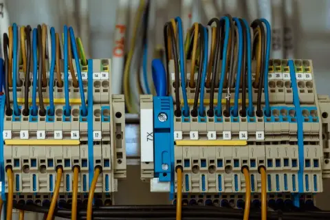 Zaciski elektryczne z kolorowymi przewodami, gotowe do podłączenia prądu budowlanego.