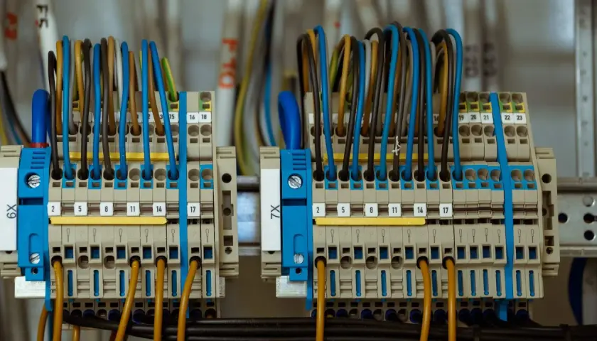 Zaciski elektryczne z kolorowymi przewodami, gotowe do podłączenia prądu budowlanego.