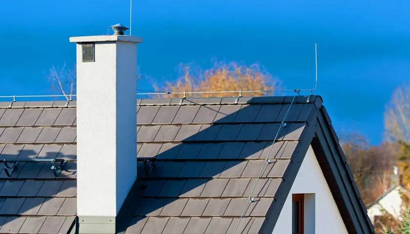 Na dachu domu widoczna jest instalacja odgromowa, chroniąca przed uderzeniami pioruna.