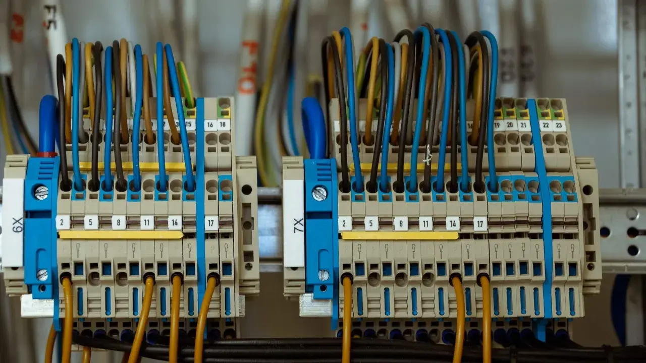 Zaciski elektryczne z kolorowymi przewodami, gotowe do podłączenia prądu budowlanego.